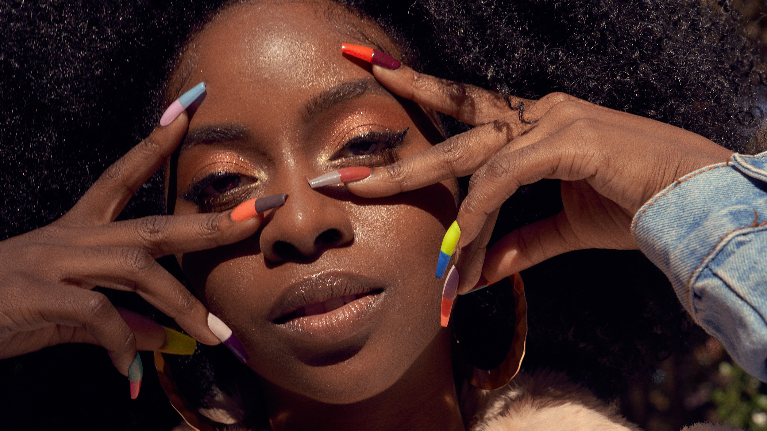 Woman posing with colorful fingernails for a Devour Nail production shoot.