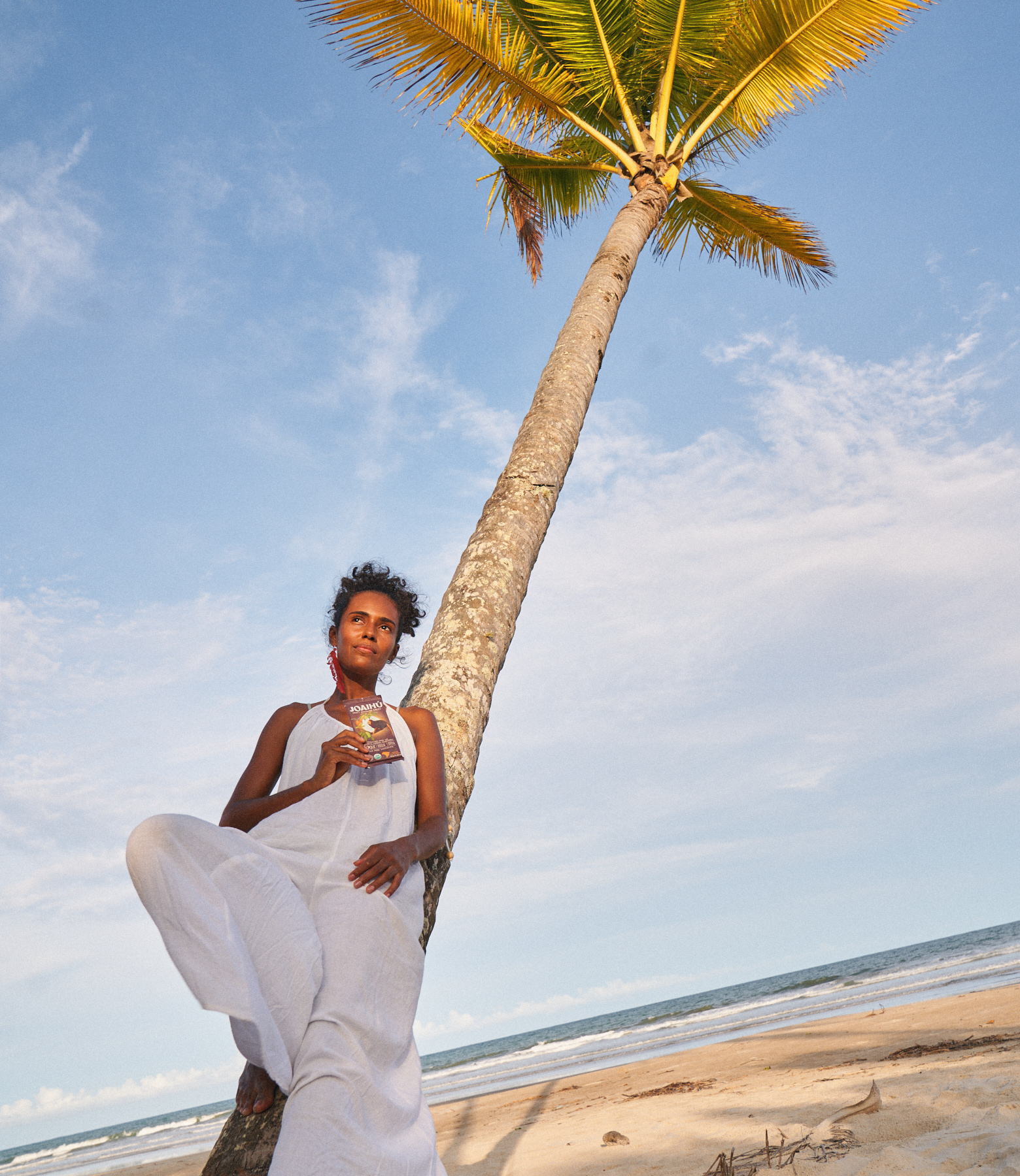 JOAIHÚ chocolate from Bahia, Brazil, woman on beach with palm tree. Production shoot.